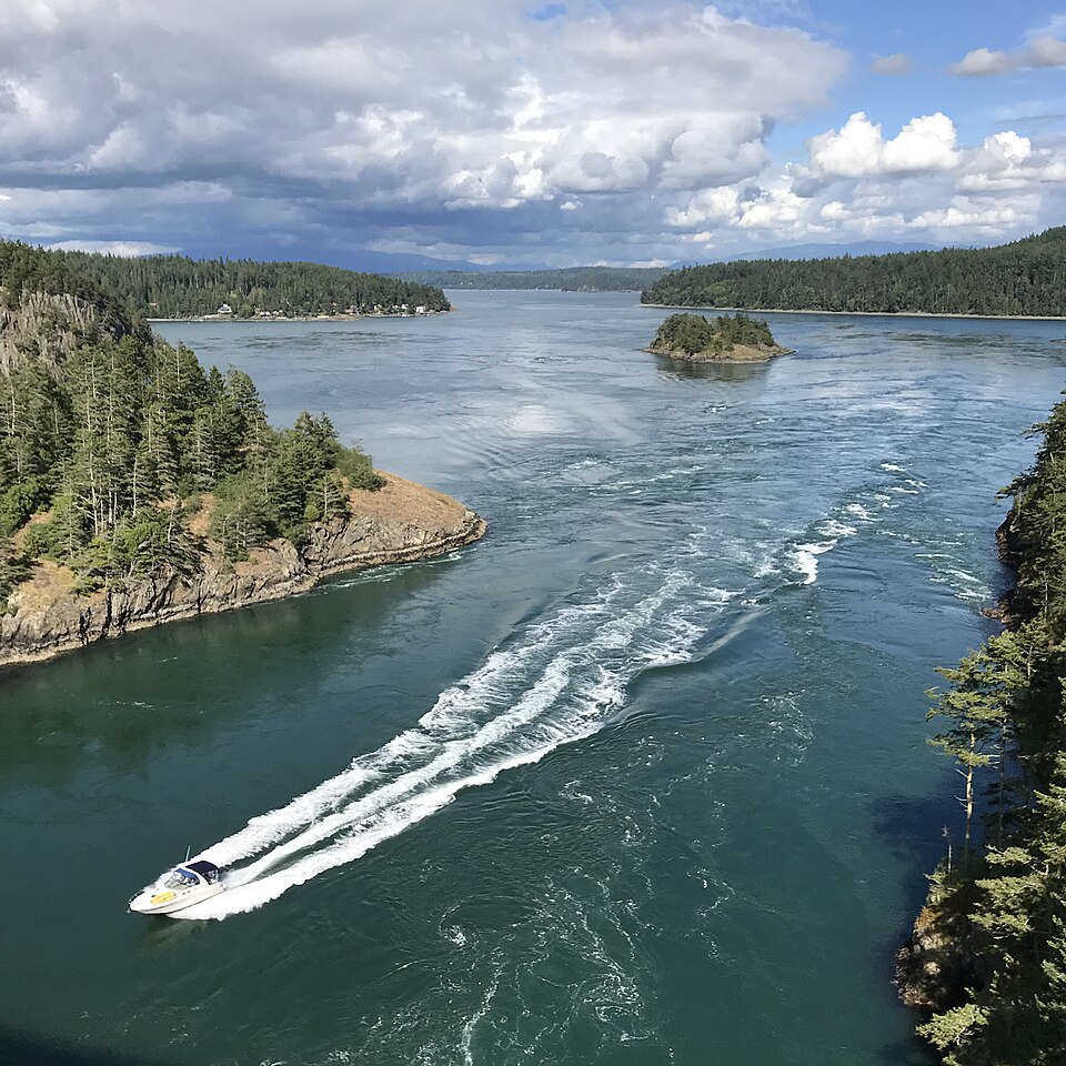 Looking east from the Deception Pass Bridge as a boat drives by — Island County, Washington